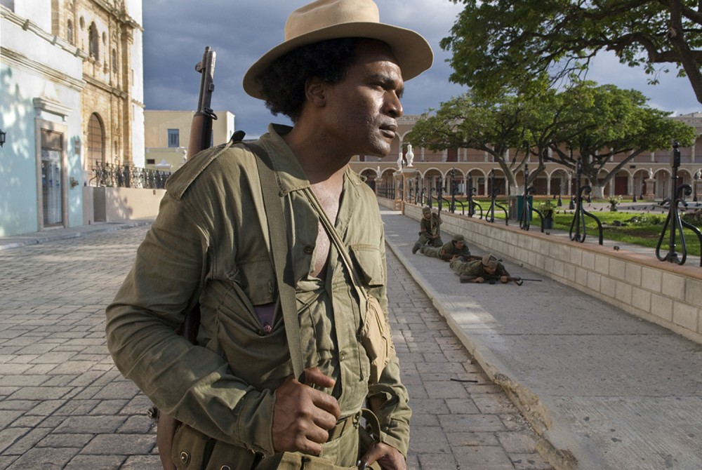 Othello Rensoli plays Pombo. Rensoli is awaiting his next scene while other actors playing rebel soldiers practice their assault on Batista’s forces holding the town square. In real life, Pombo also fought with Che to create a revolution in Bolivia in 